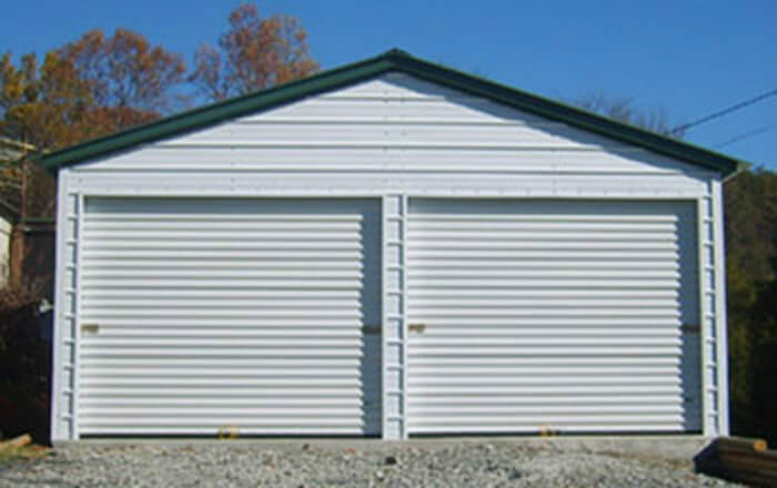 White steel building with end doors with enough area to park two vehicles plus storage area.