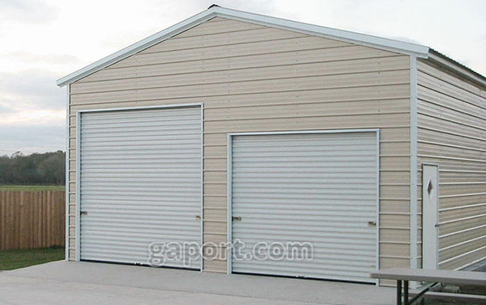 Tan garage with concrete slab base and two roll-up garage doors on the end.