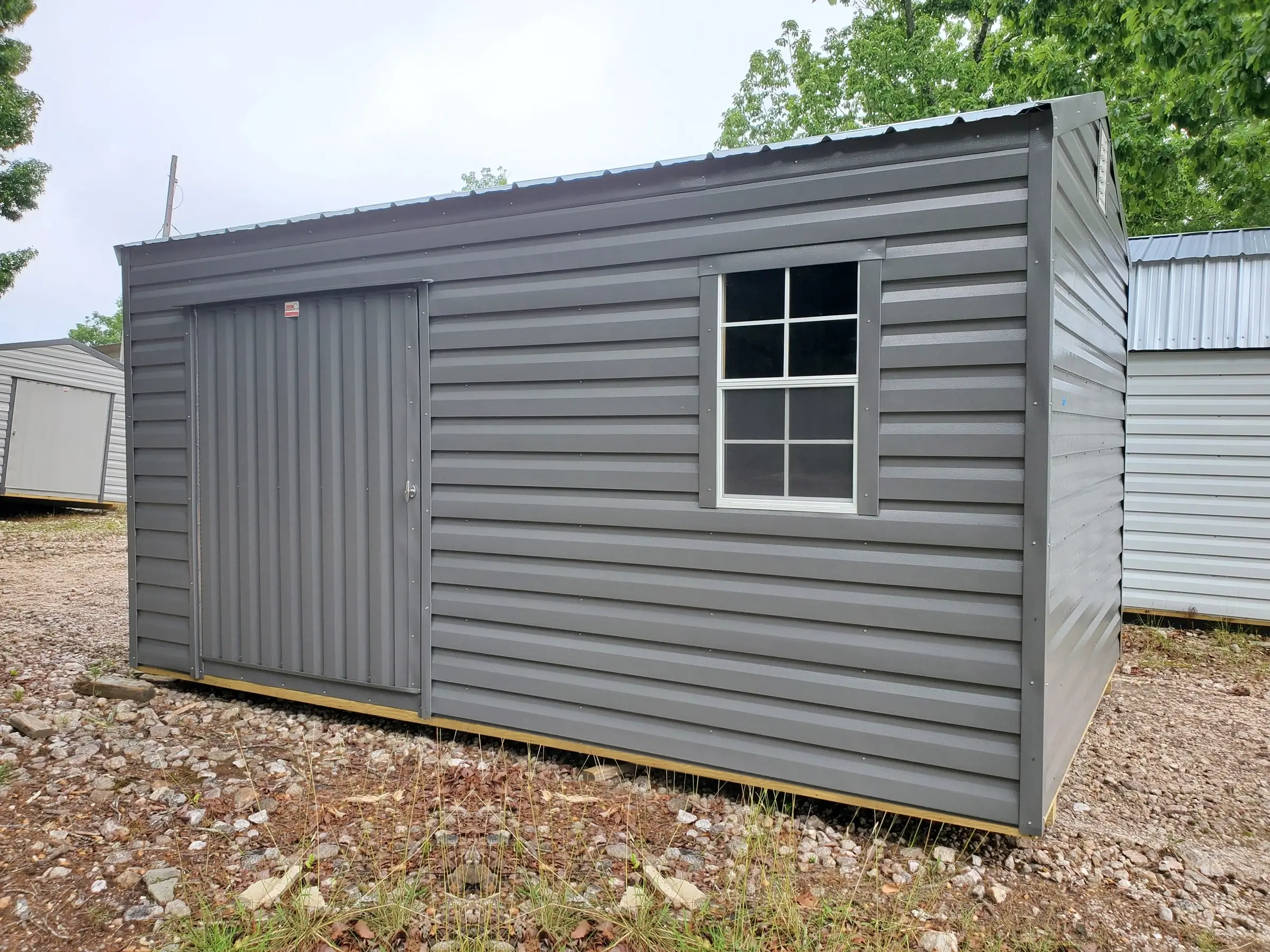 Front view of the all gray 10x16 portable building with large door and window.
