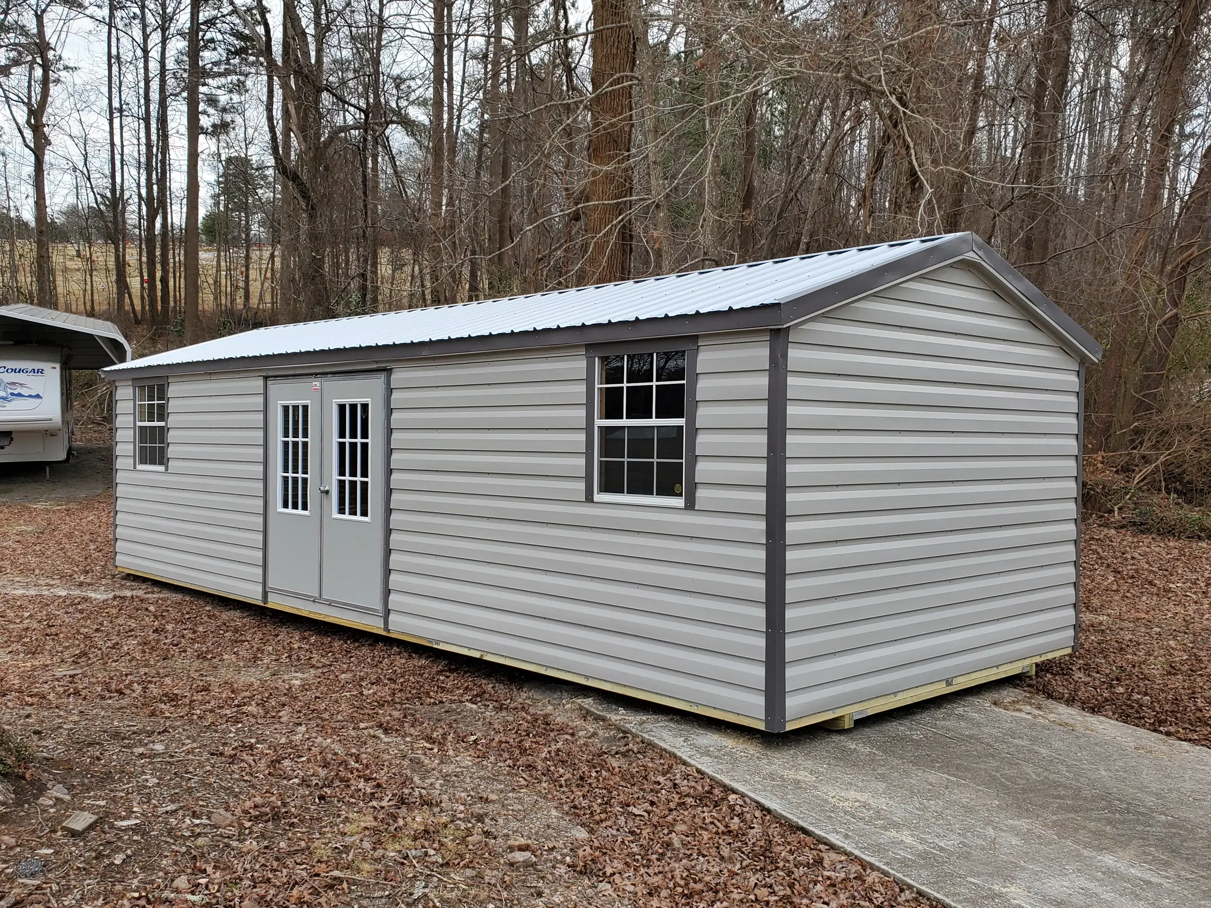 Classic style 12 by 30 portable shed building with multiple windows and doors.