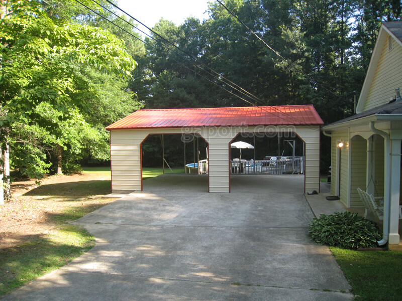 Front view of attractive two car side entry carport with beige siding.
