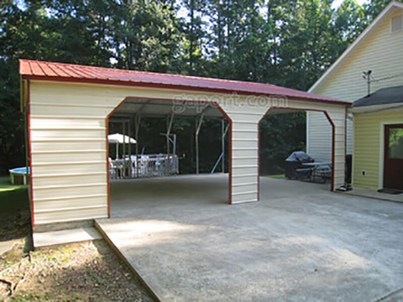 Angled view of nice double car side entry carport next to a house.