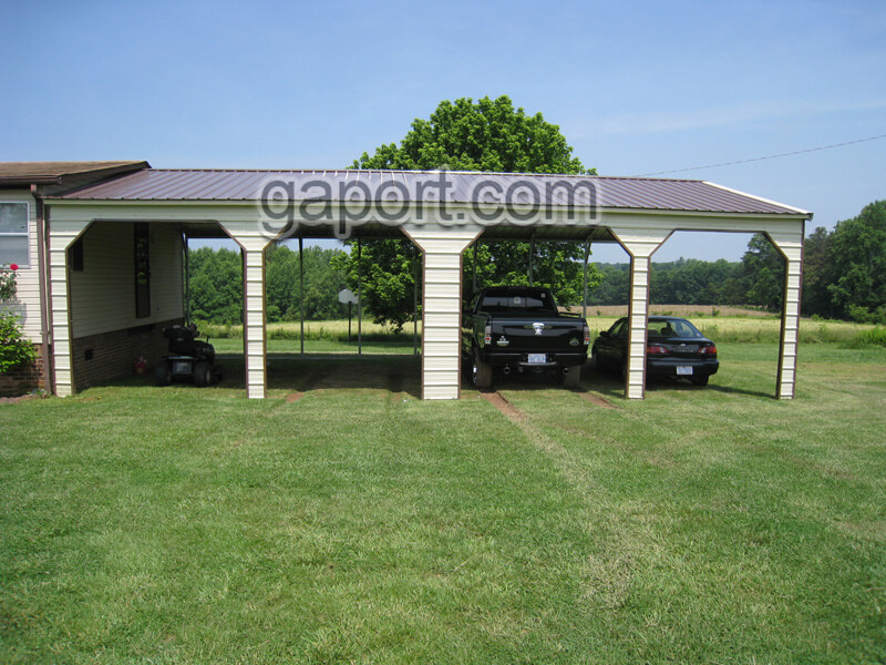 Front view of aesthetically pleasing four car side entry metal carport with beige siding.
