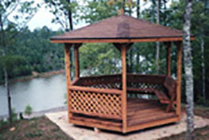 At a lake side setting, an 8x8 round gazebo with a shingled roof.