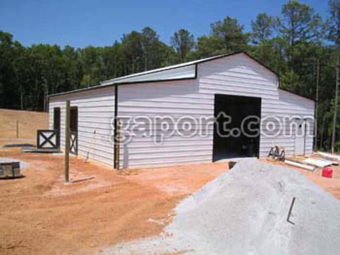 white metal horse barn with black trim